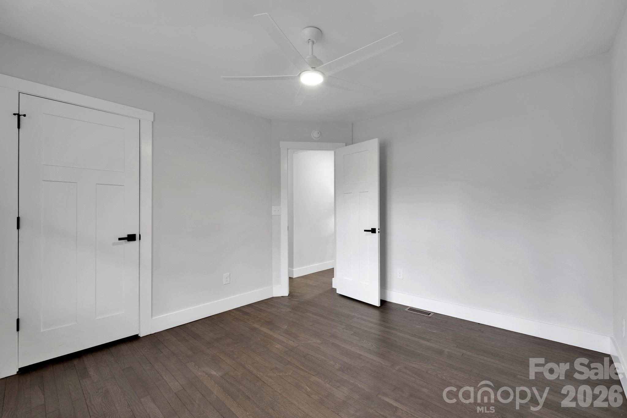 5413 Ruth Drive Charlotte, NC 28215 - Photo 19 of 29 a view of an empty room with wooden floor and a ceiling fan