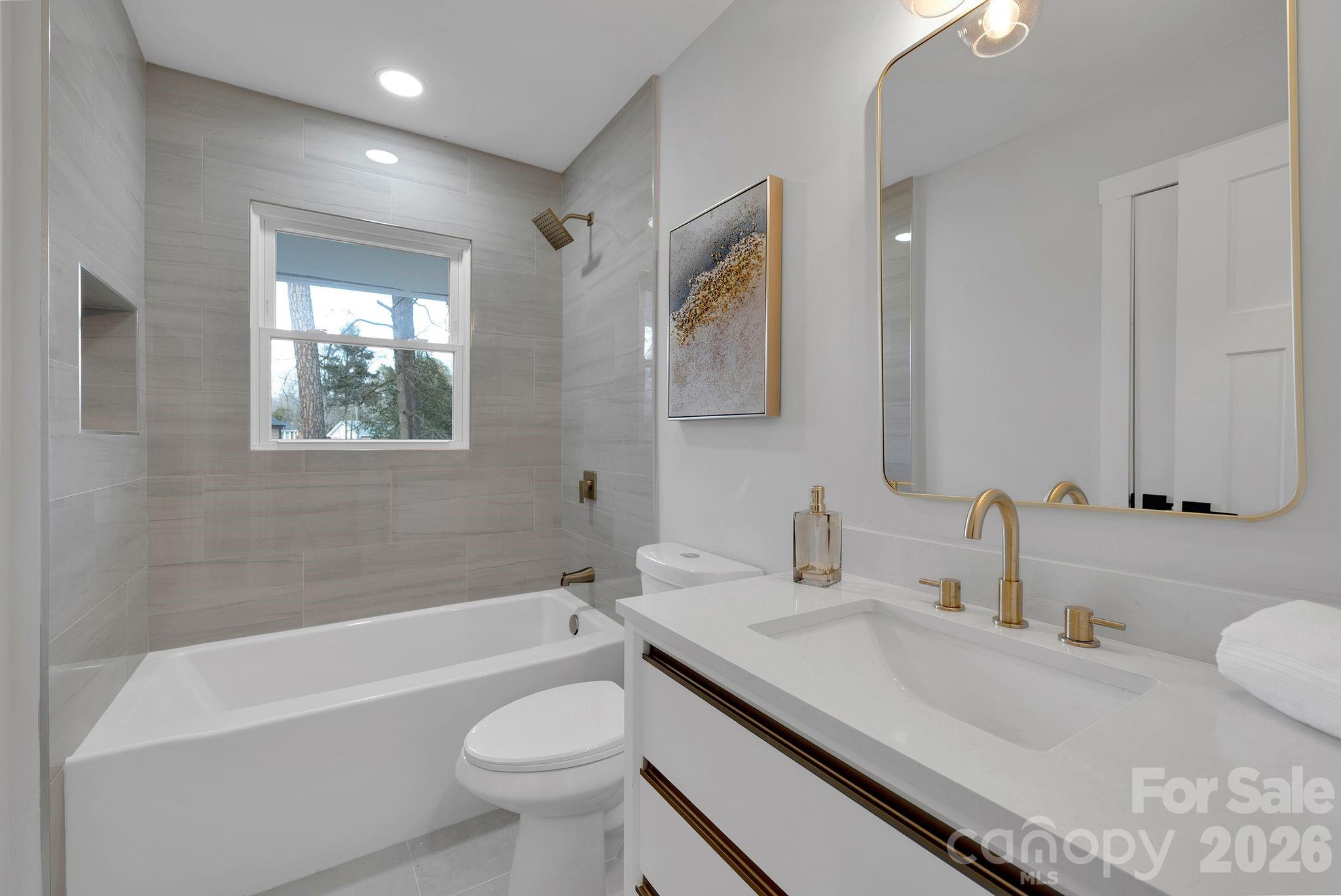 5413 Ruth Drive Charlotte, NC 28215 - Photo 20 of 29 a bathroom with a granite countertop sink a toilet a mirror and bathtub