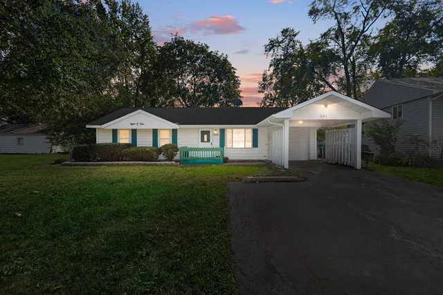 a front view of a house with a yard and trees