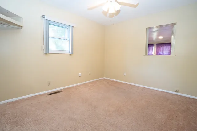 an empty room with a chandelier fan