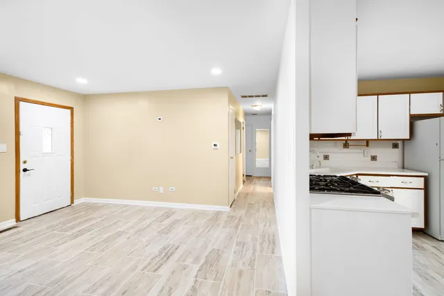 a kitchen with stainless steel appliances a refrigerator a stove a sink and white cabinets