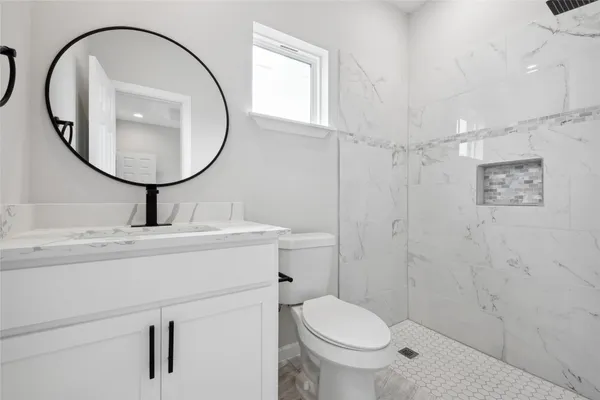 a bathroom with a sink a toilet and a mirror