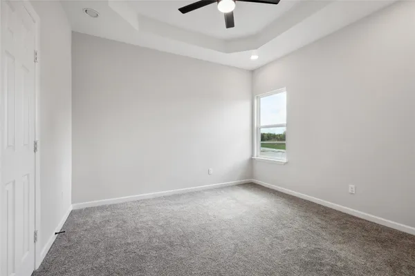 an empty room with a window and a fan