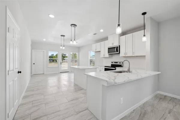 a kitchen with cabinets appliances a sink and a window