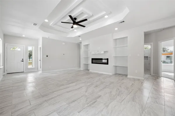 a view of empty room with wooden floor and window