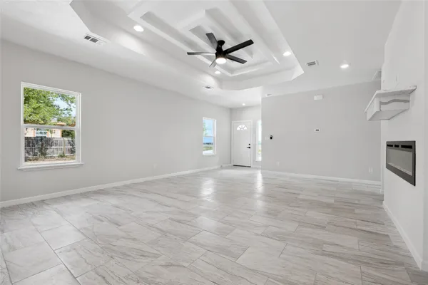 an empty room with ceiling fan and window
