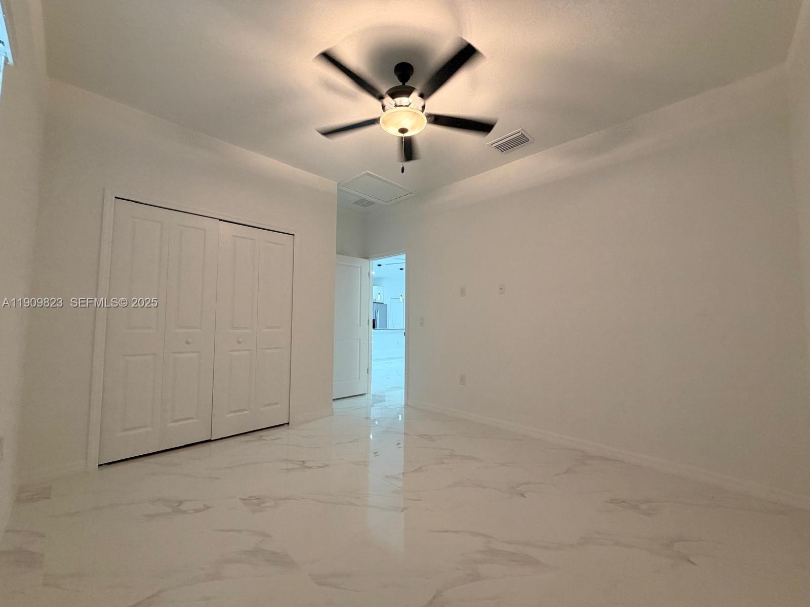 2706 72nd Street West Lehigh Acres, FL 33971 - Photo 11 of 21 an empty room with ceiling fan and window