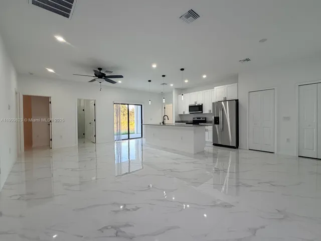 a view of a hallway with stainless steel appliances