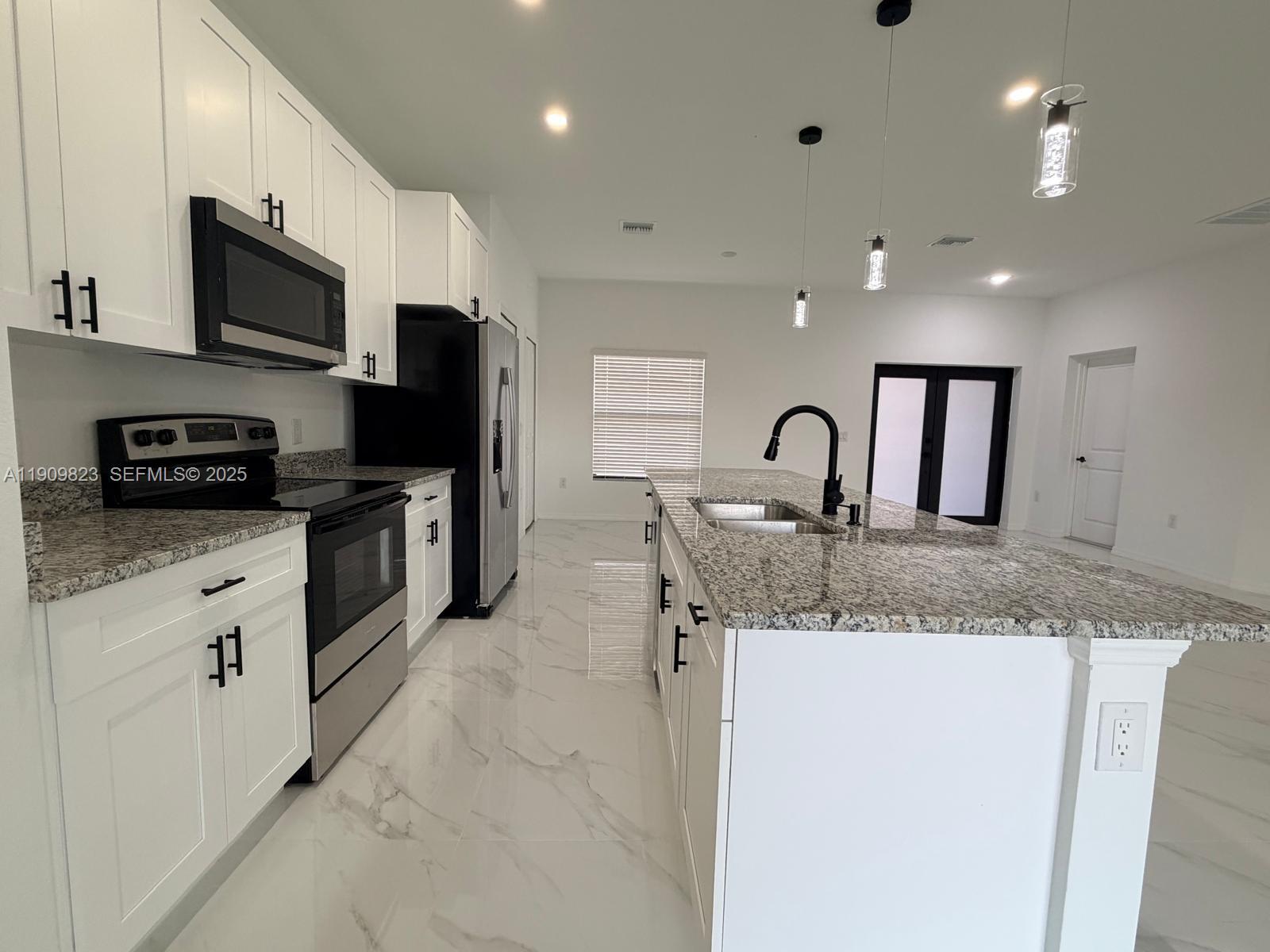 2706 72nd Street West Lehigh Acres, FL 33971 - Photo 4 of 21 a kitchen with granite countertop a sink and stainless steel appliances