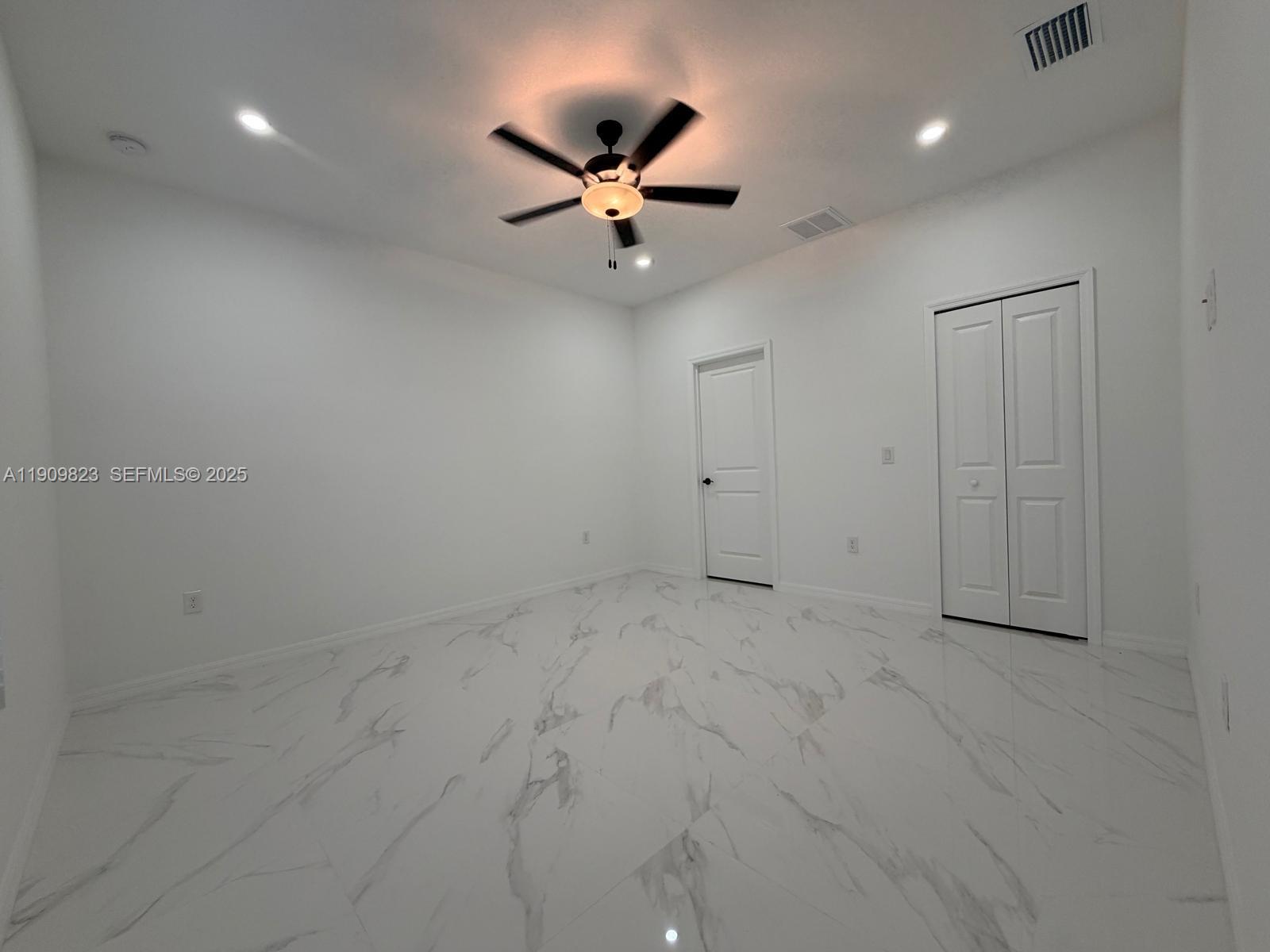 2706 72nd Street West Lehigh Acres, FL 33971 - Photo 7 of 21 an empty room with a ceiling fan and window