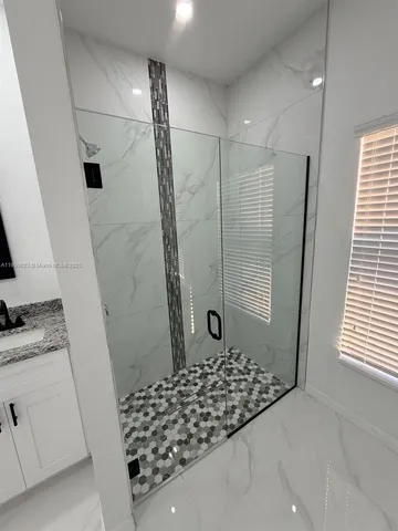 a bathroom with granite countertop double vanity sink and mirror