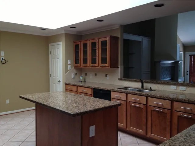 a kitchen with granite countertop kitchen island a sink and cabinets
