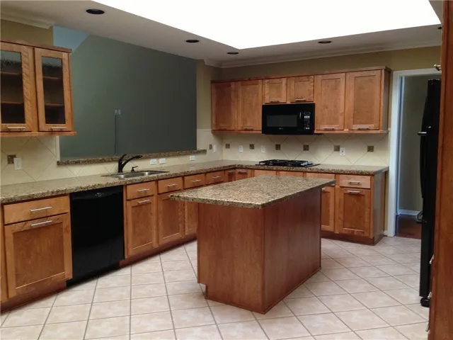 a kitchen with a sink a stove top oven and cabinets