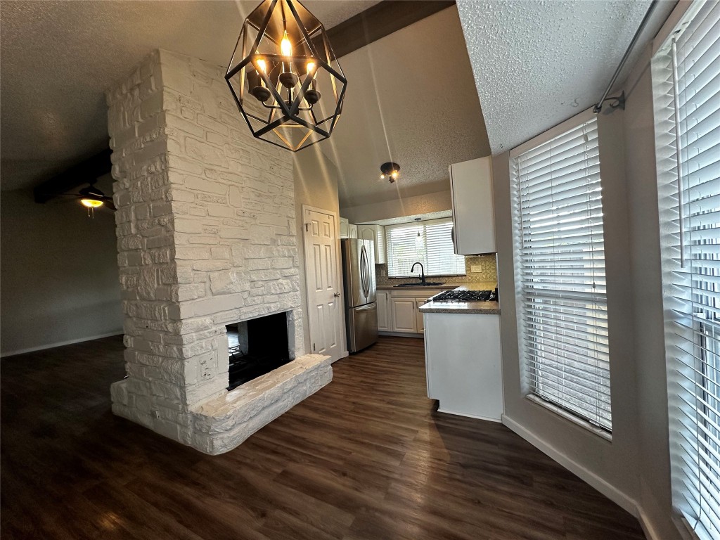 504 Suzzane Road Pflugerville, TX 78660 - Photo 4 of 15 a kitchen with a chandelier and fireplace