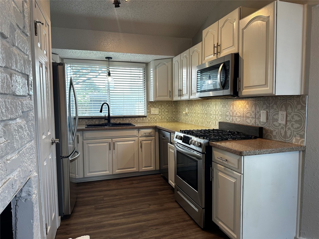 504 Suzzane Road Pflugerville, TX 78660 - Photo 5 of 15 a kitchen with stainless steel appliances granite countertop a sink and a microwave