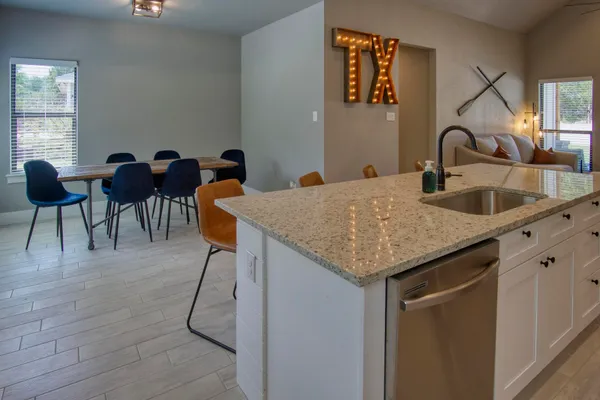 a kitchen with a sink a table and chairs in it