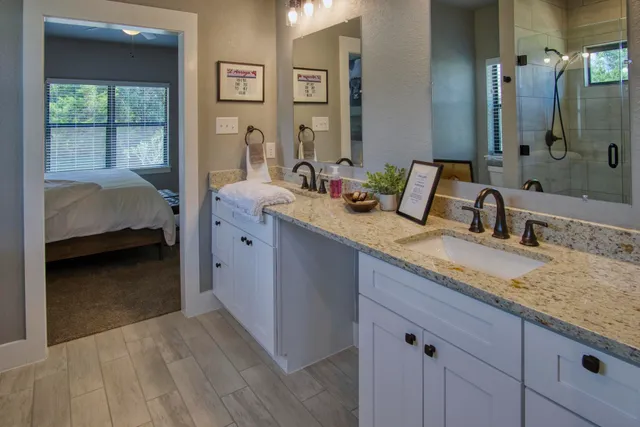 a en suite bathroom with a granite countertop sink and a mirror