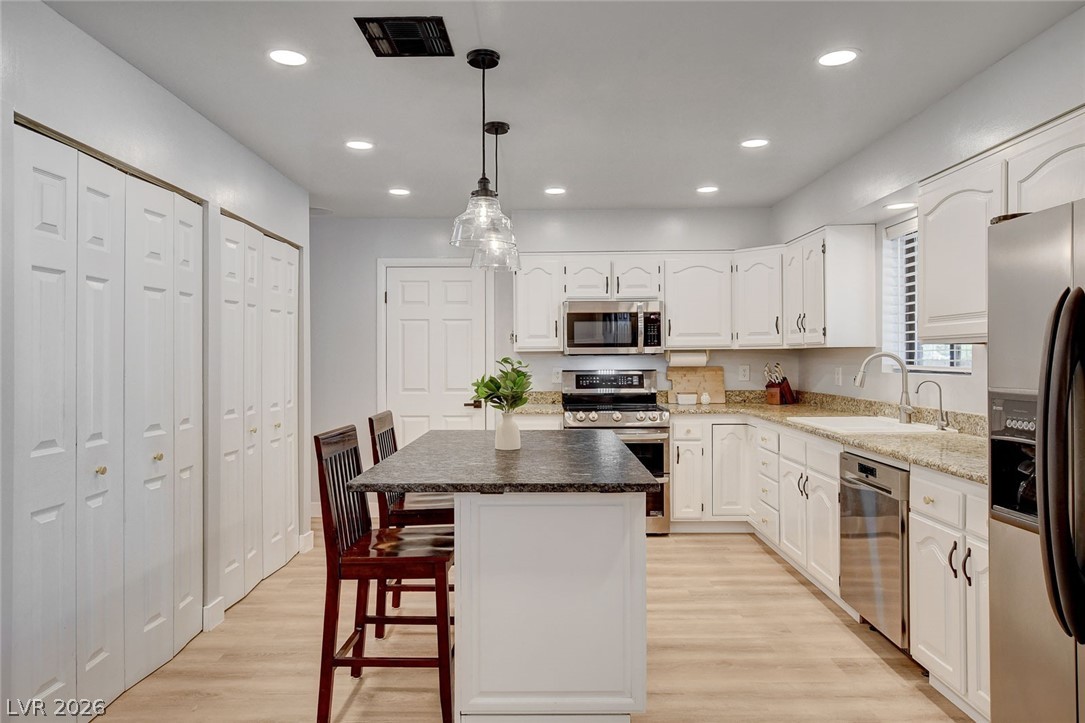 3765 Berkeley Street Logandale, NV 89021 - Photo 27 of 87 This modern kitchen features bright cabinetry, sleek appliances, and a functional island, creating an inviting culinary space.