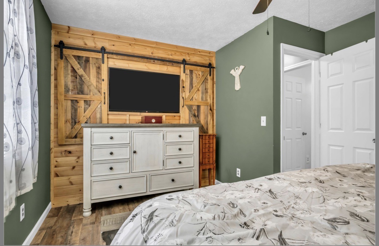 1051 Twin Pine Road Dickson, TN 37055 - Photo 22 of 29 a bedroom with a bed and a flat tv screen in it