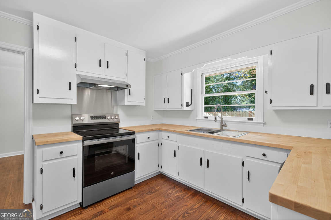 352 3rd Avenue Winder, GA 30680 - Photo 13 of 33 a kitchen with granite countertop white cabinets and stainless steel appliances