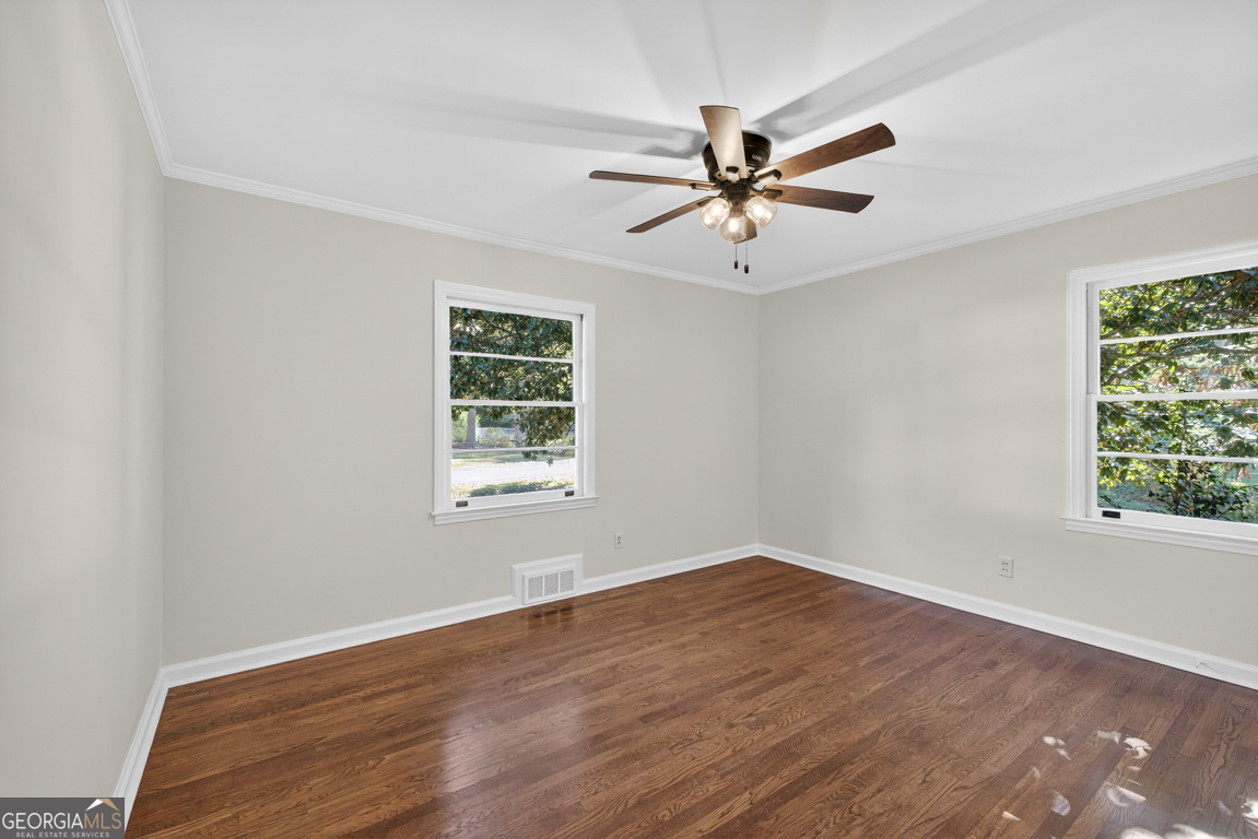 352 3rd Avenue Winder, GA 30680 - Photo 21 of 33 an empty room with wooden floor fan and windows