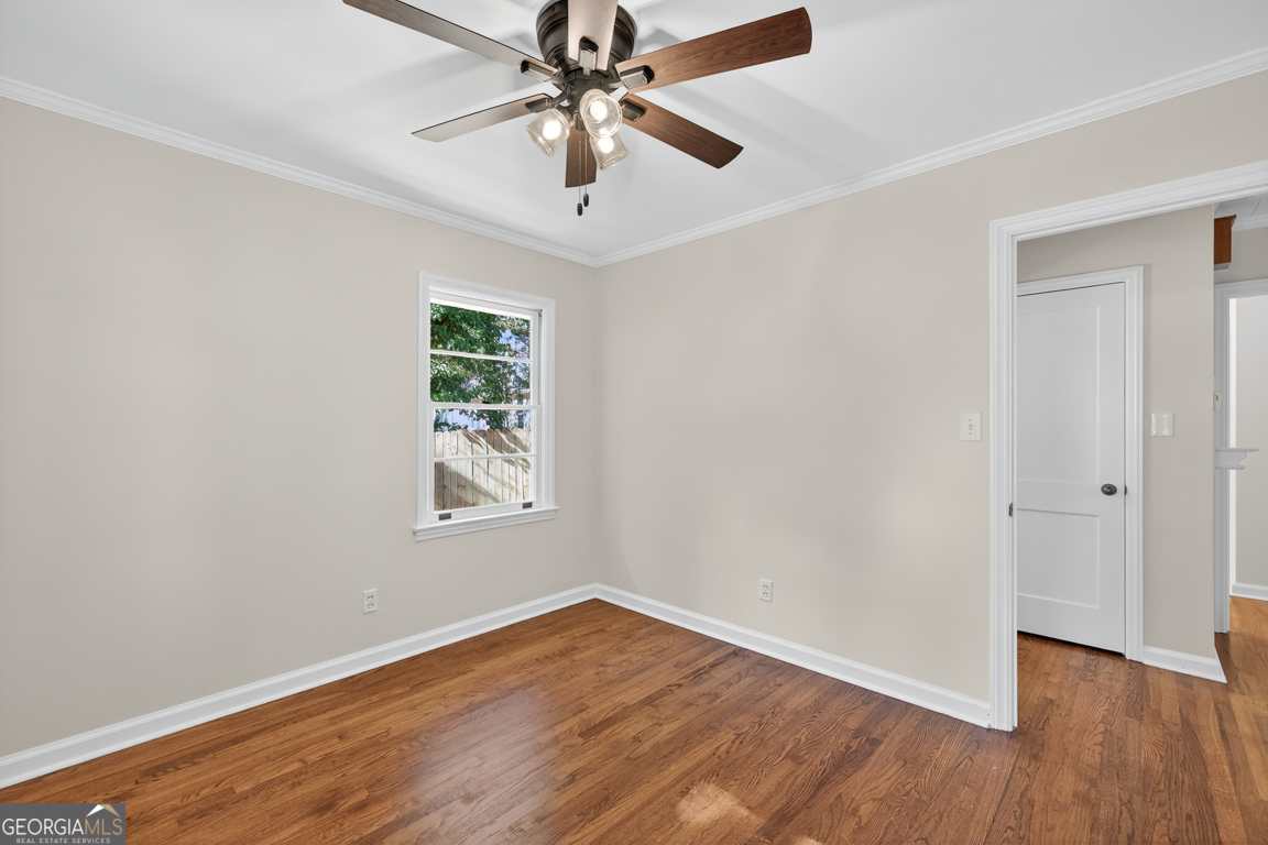 352 3rd Avenue Winder, GA 30680 - Photo 25 of 33 an empty room with wooden floor chandelier fan and windows