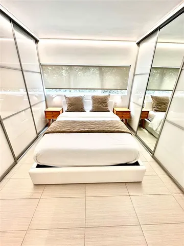 a bedroom with a bed and a large mirror