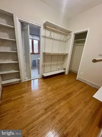 a spacious bathroom with a granite countertop sink a toilet a mirror and shower