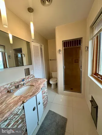 an empty room with wooden floor chandelier fan and windows