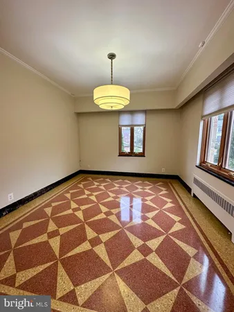 a room with a black white checkered floor with a gaming machine and dining chairs