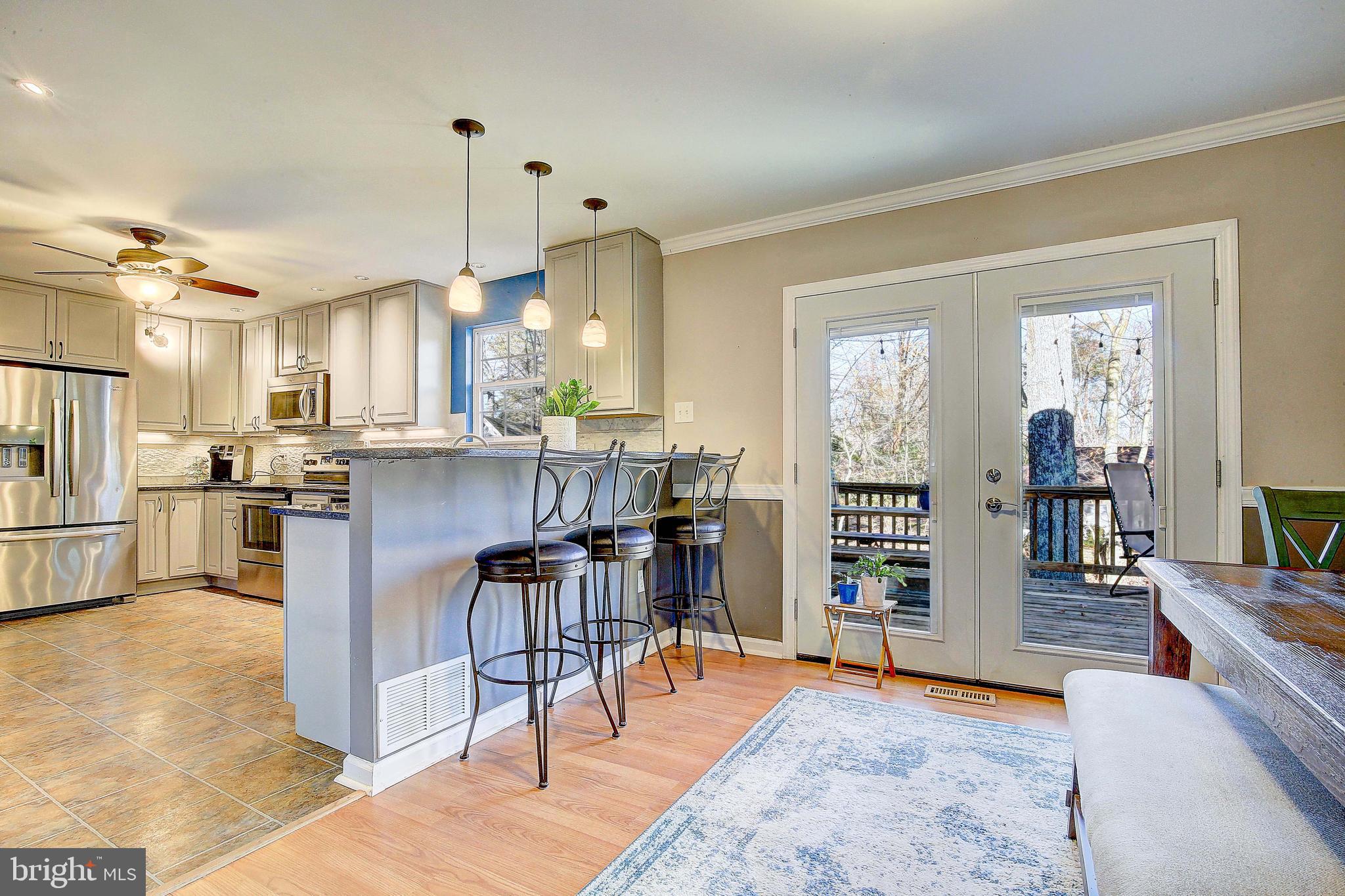 342 Metropolitan Boulevard Pasadena, MD 21122 - Photo 14 of 47 a kitchen with stainless steel appliances kitchen island granite countertop wooden cabinets and dining table