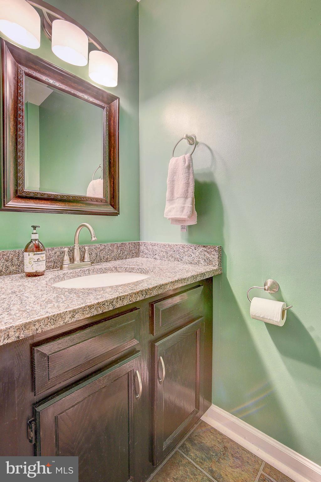342 Metropolitan Boulevard Pasadena, MD 21122 - Photo 17 of 47 a bathroom with a granite countertop sink and a mirror