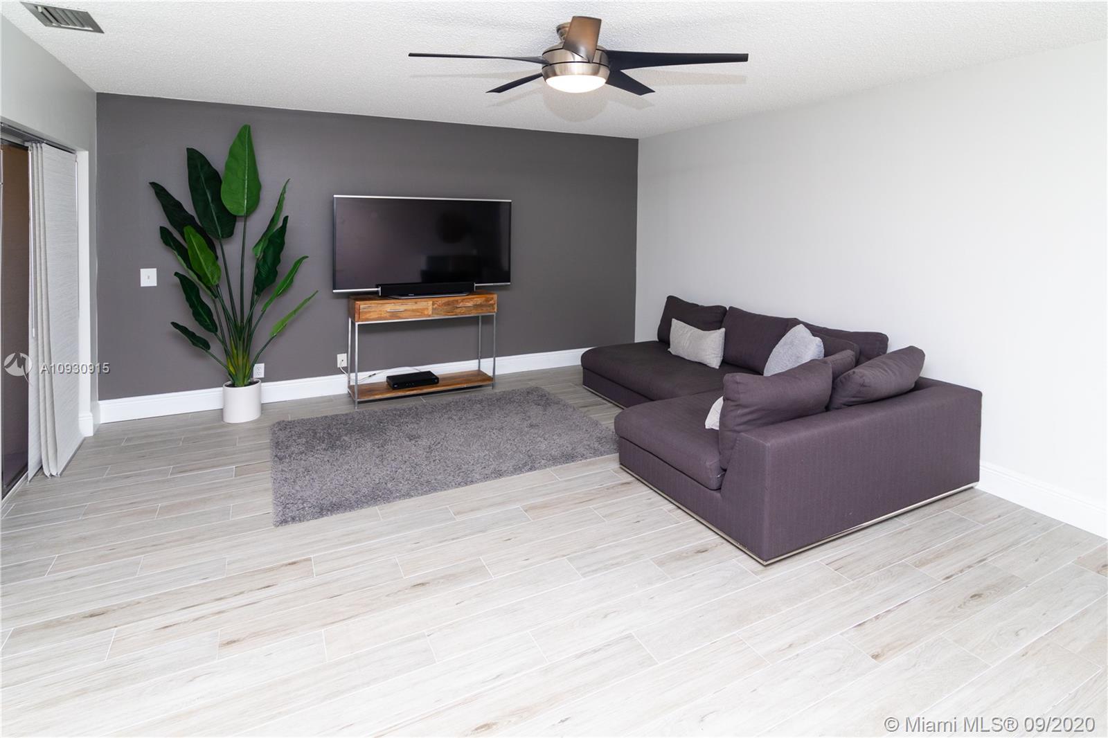 6607 Via Regina Boca Raton, FL 33433 - Photo 11 of 40 a living room with furniture and a flat screen tv