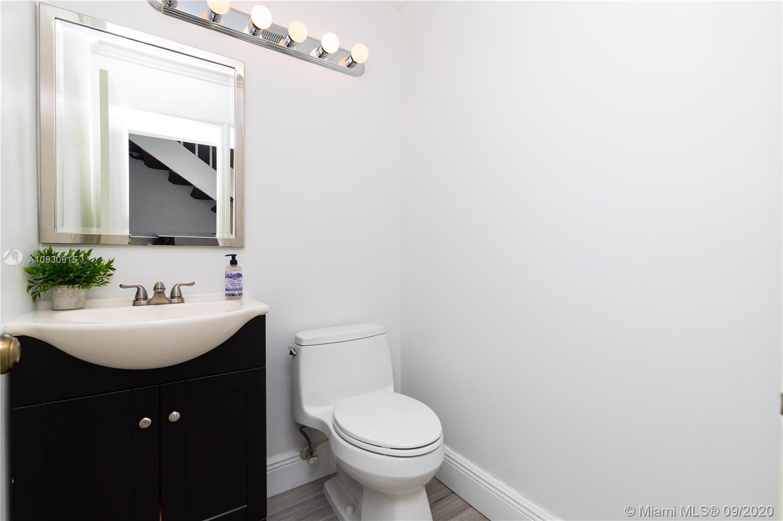 6607 Via Regina Boca Raton, FL 33433 - Photo 13 of 40 a bathroom with a toilet a sink and mirror