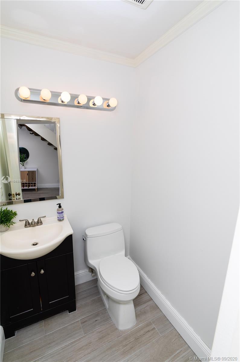 6607 Via Regina Boca Raton, FL 33433 - Photo 14 of 40 a bathroom with a toilet a sink and mirror