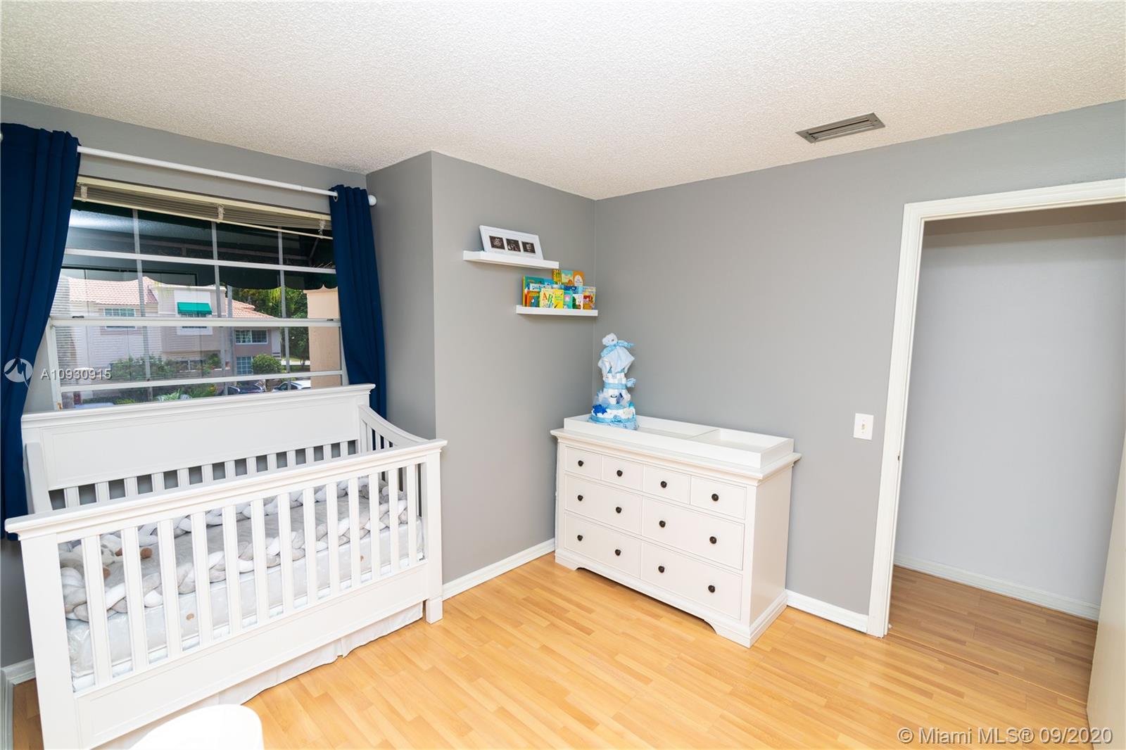 6607 Via Regina Boca Raton, FL 33433 - Photo 17 of 40 a bedroom with furniture and baby crib