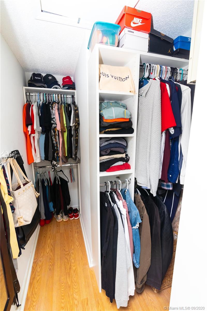 6607 Via Regina Boca Raton, FL 33433 - Photo 24 of 40 a view of walk in closet with clothes and shoes