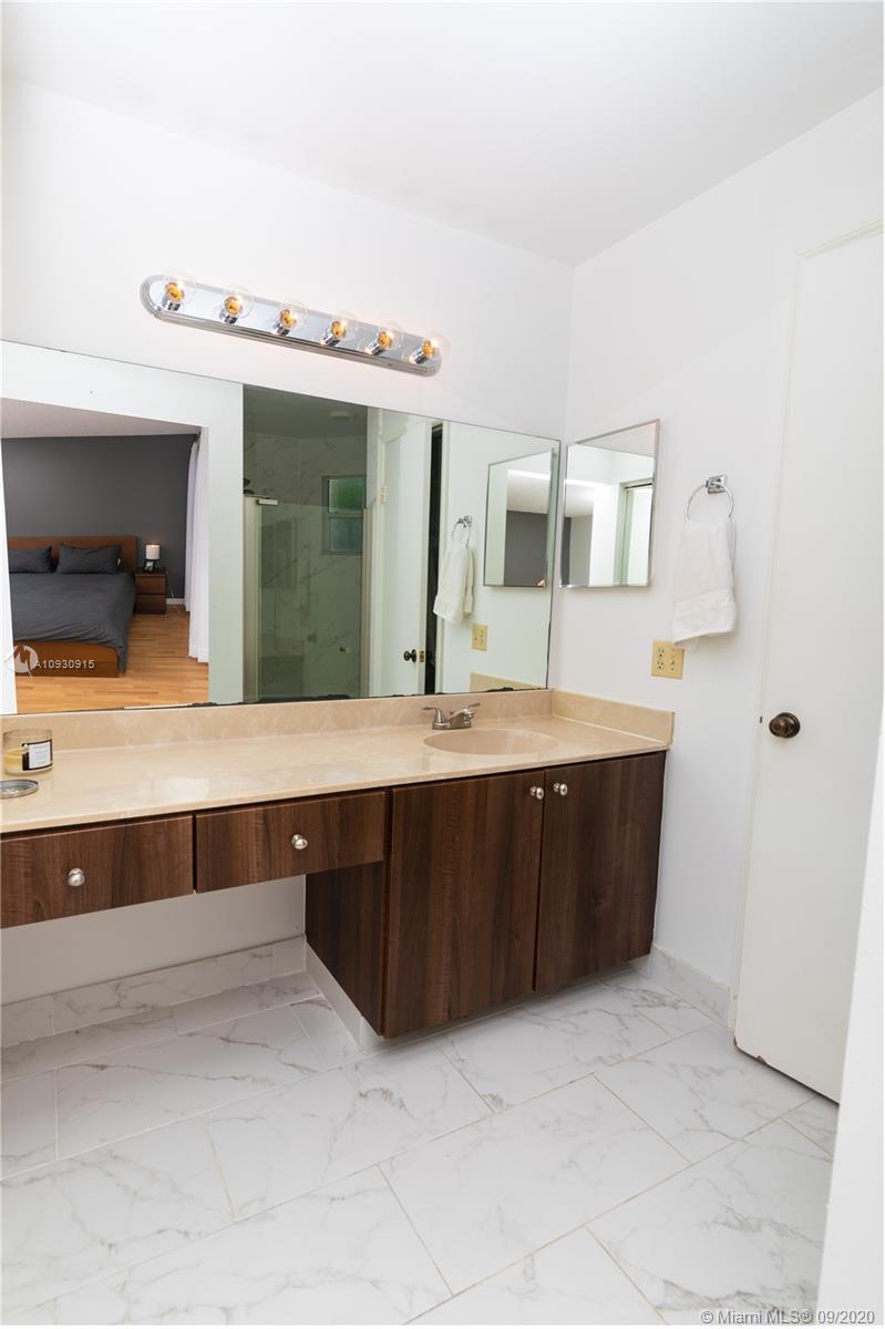 6607 Via Regina Boca Raton, FL 33433 - Photo 27 of 40 a bathroom with a sink a large mirror and vanity