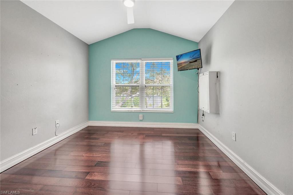 15845 Marcello Circle, Unit 83 Naples, FL 34110 - Photo 12 of 15 Third bedroom featuring lofted ceiling and dark hardwood / wood-style floors