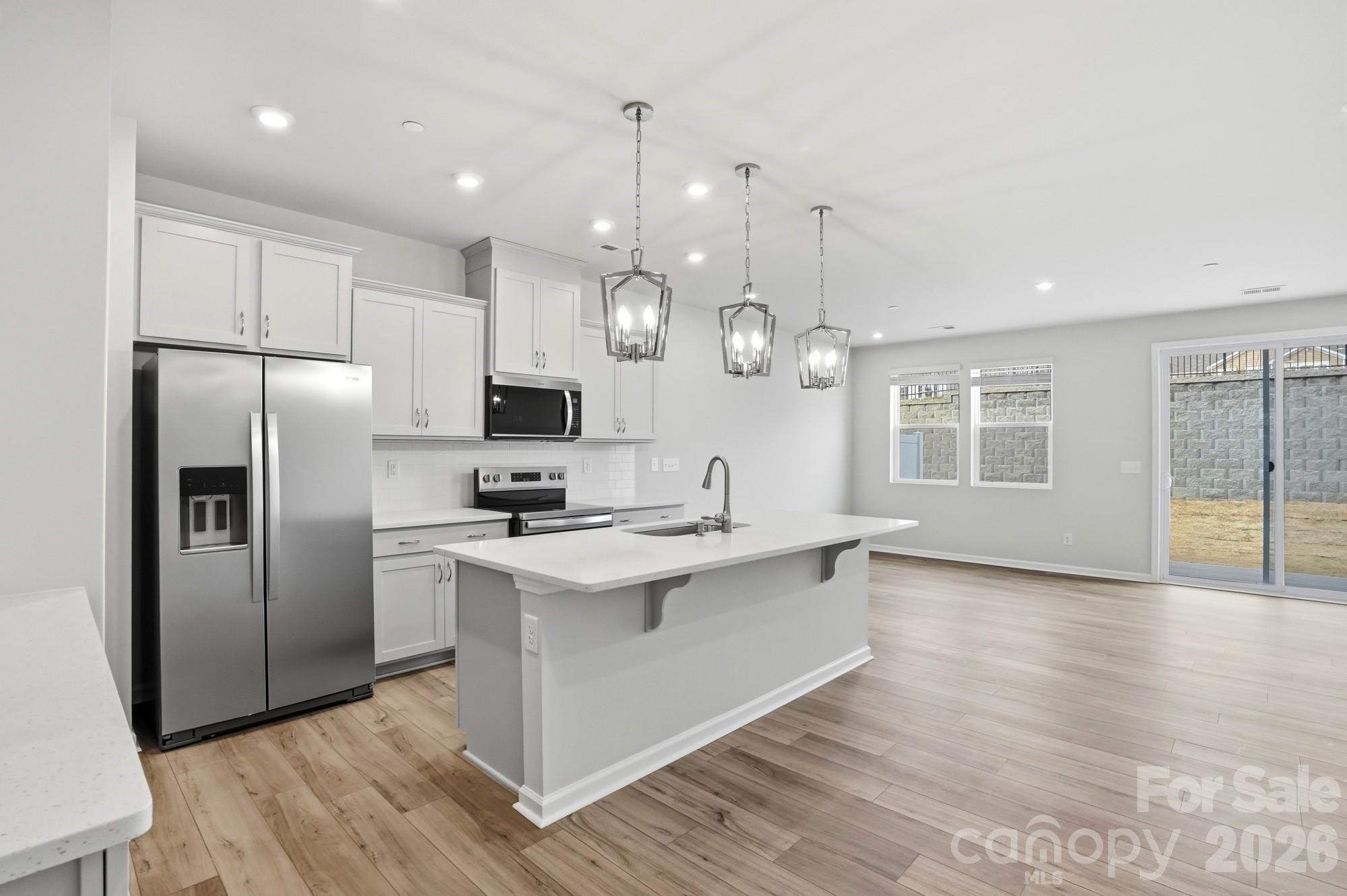 2540 Hedgecliff Road Kannapolis, NC 28083 - Photo 4 of 22 a kitchen with stainless steel appliances granite countertop a refrigerator a sink dishwasher a stove and white countertops with wooden floor