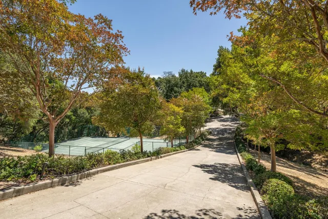a view of a tennis court with trees in the background