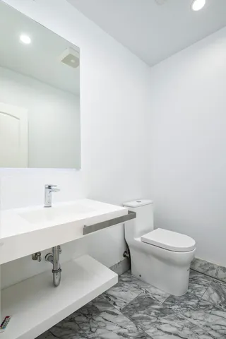 a front view of a house with a yard and potted plants