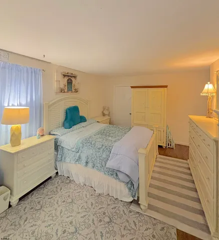 a spacious bedroom with a bed and a lamp on table