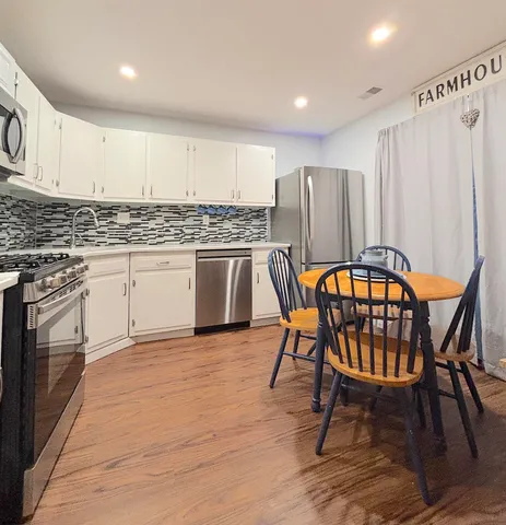 a kitchen with stainless steel appliances granite countertop a stove top oven a sink dishwasher and a refrigerator