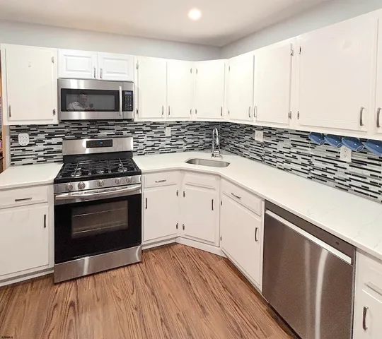 a kitchen with granite countertop a stove and a microwave