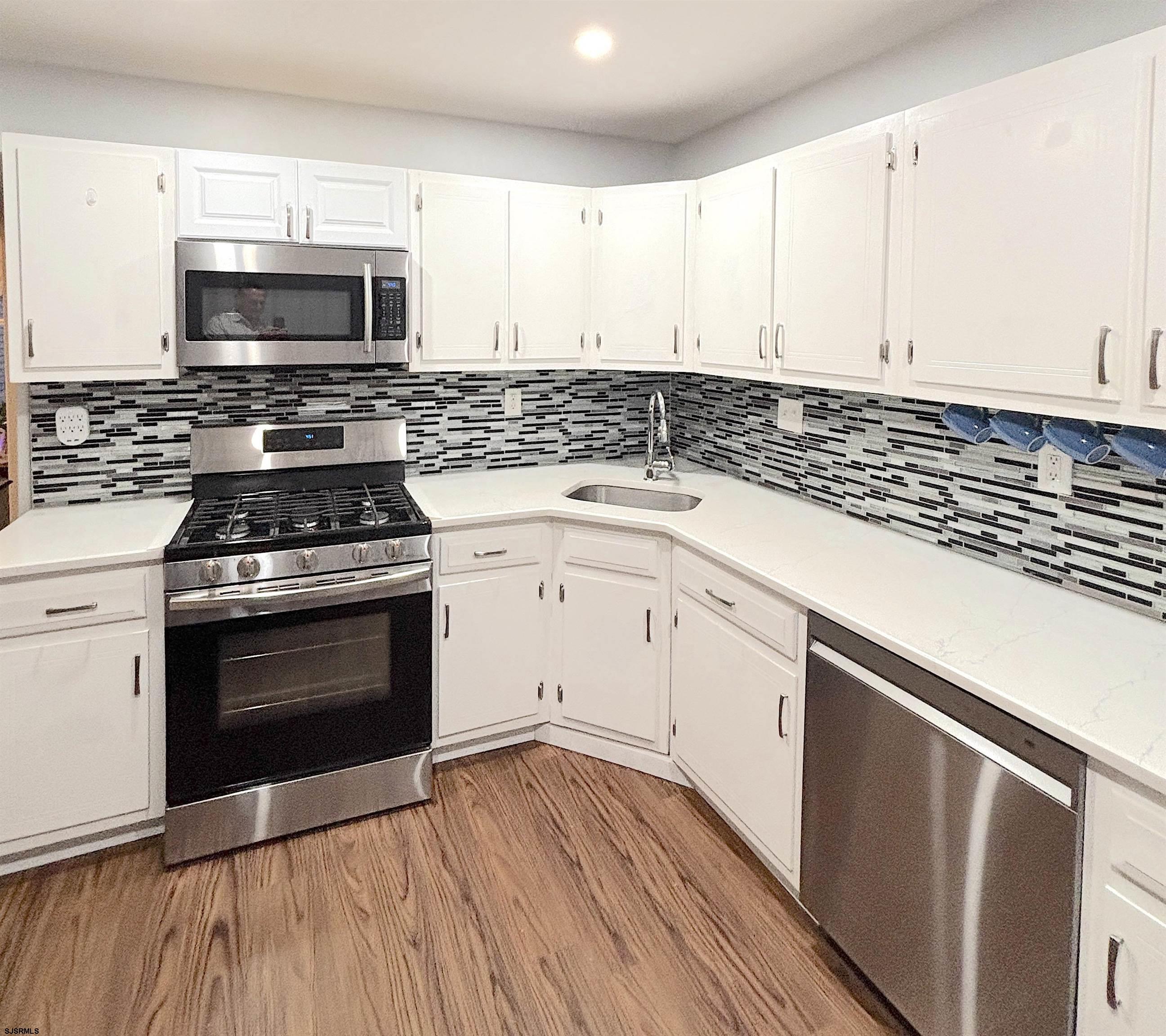 407 Mason Run, Unit 407 Clementon, NJ 08021 - Photo 5 of 22 a kitchen with granite countertop a stove and a microwave