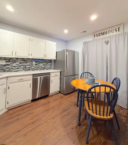 a kitchen with stainless steel appliances wooden floors and wooden cabinets