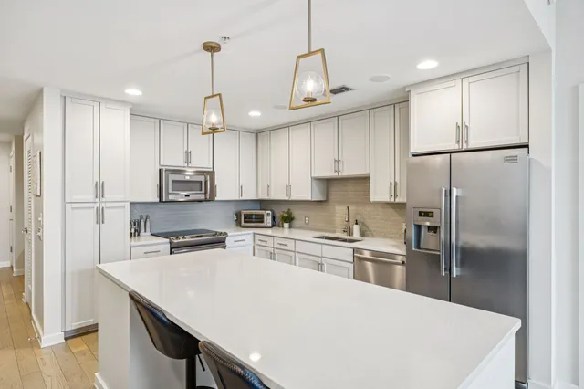 a kitchen with kitchen island a refrigerator a stove a sink and a center island