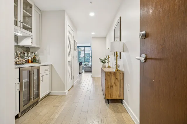 a view of a hallway with wooden floor and a bathroom