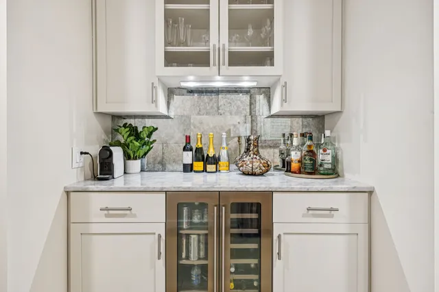 a kitchen with stainless steel appliances granite countertop white cabinets and a potted plant